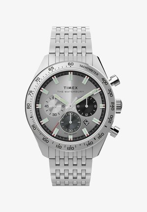 Zegarek Timex Waterbury z bransoletą ze stali nierdzewnej w kolorze srebrnym, srebrną tarczą, trzema sub-tarczami chronografu oraz oznaczeniami tachymetru wzdłuż obrzeża.