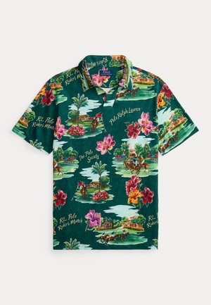 Polo vert avec imprimés floraux colorés et joueur de polo, comportant les inscriptions "Polo Ralph Lauren" et des motifs de texte associés sur l'ensemble.