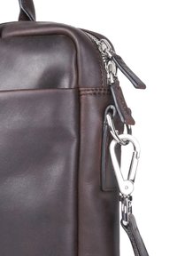 Borsa in pelle marrone scuro con texture liscia, cuciture rinforzate, una cerniera argento e un dettaglio in metallo con chiusura.