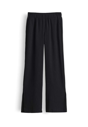 Pantaloni neri a gamba larga con vita elasticizzata e spacchi laterali all’orlo, realizzati in tessuto crêpe leggero.