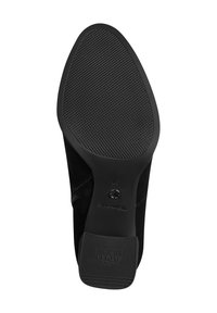 Semelle de chaussure en daim noir avec surface en caoutchouc texturée, bout rond et logo de la marque visible. Le design met l'accent sur l'adhérence et la stabilité. Taille 37.