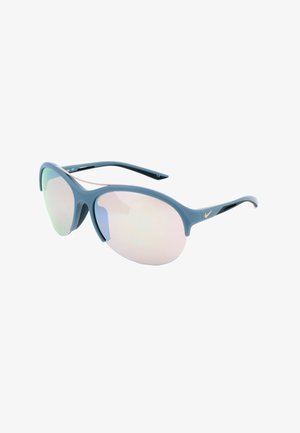 Occhiali da sole sportivi con montatura blu, lenti ovali riflettenti e piccolo logo Nike argentato sulla stanghetta, esposti su sfondo bianco.
