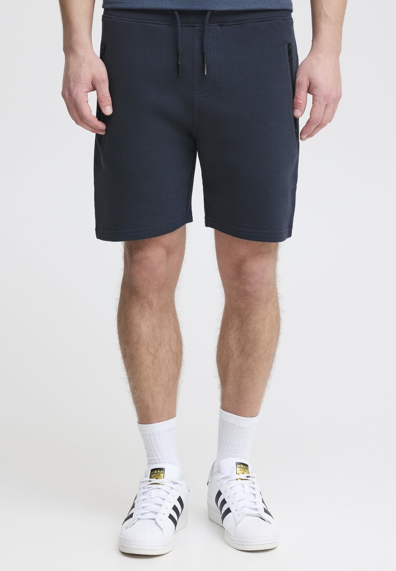 Navyblauwe sweatshorts van een textuurstof, met een elastische tailleband en een trekkoord. Heeft zijzakken met rits en een rechte snit.