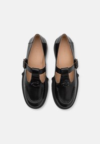 Melnas ādas kurpes ar noapaļotu purngalu, Mary Jane stila siksniņu un logotipa akcentu. Gluda virsma un mīkstināta ieliktnis.