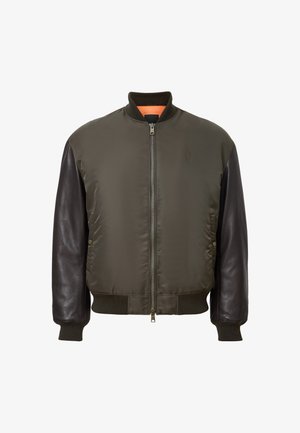 Chaqueta bomber verde con mangas de cuero marrón oscuro, cuello y puños acanalados, cremallera frontal y bolsillos laterales con botones de presión.