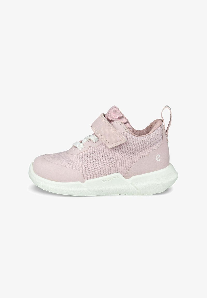 Różowy but sportowy z siateczkową cholewką, zapięciem na rzep i białą podeszwą; charakteryzuje się fakturowanym wzornictwem i pętelką na pięcie.