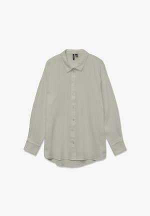 Gaiši pelēka, pogājama, garām piedurknēm krekls ar smalku tekstūru. Ievērojamā iezīme ir norādīta apkakle un nedaudz izliekta apakšmala.