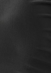 Svarta texturerade leggings gjorda av ett slätt, stretchigt material, med en åtsittande design och en subtil lyster.