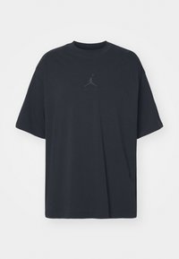 Czarny oversize t-shirt z krótkim rękawem, okrągłym dekoltem i subtelnie wytłoczonym logo Air Jordan Jumpman wyśrodkowanym na klatce piersiowej.