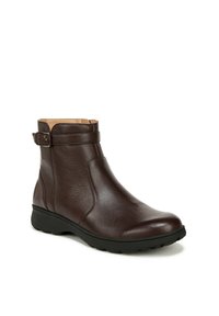 Bottine en cuir marron avec une texture lisse, détail de boucle sur le côté et semelle en caoutchouc. Bout arrondi et design à faible hauteur pour plus de confort.