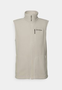 Beige ärmlös fleeceväst med hög krage, dragkedja framtill och två sidofickor. Liten ficka med dragkedja på bröstet. Logotyp på övre vänstra sidan. Mjuk textur.