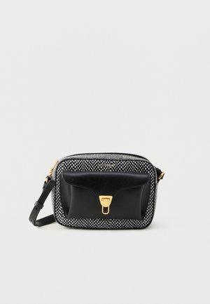 Czarna skórzana torba na ramię z białym wzorem w kropki, złotymi elementami, przednią kieszenią i regulowanym paskiem. Kompaktowy, prostokątny kształt.