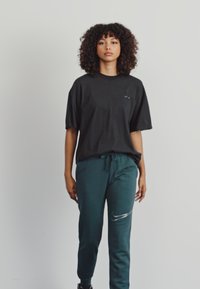 Nike Sportswear CLUB SHINE PANTS - Teplákové kalhoty - deep jungle