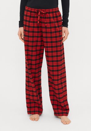 Red and black plaid pajama pants with a loose fit, elastic waistband, and drawstring, made from soft material, suitable for casual wear.