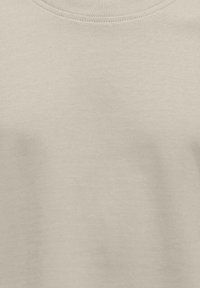 Lys beige bomuldsstof med en glat overflade og en rundudskæring. Minimalistisk design uden mønstre eller yderligere detaljer.