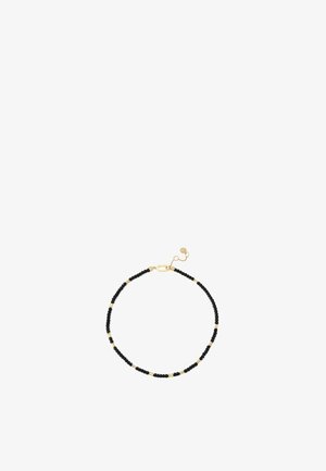 Bracciale con perline nere e dorate, chiusura in oro e catena regolabile su sfondo bianco.