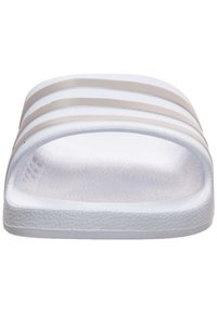 Sandale blanche avec trois épais stripes gris. Dispose d'un semelle intérieure texturée et d'une matière supérieure lisse. Design minimaliste.