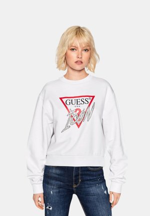 Felpa bianca con logo triangolare rosso con la scritta "GUESS U.S.A." e "ICON" in lettere argentate. Maniche e orlo a coste, vestibilità comoda.