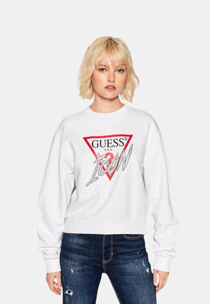 Witte sweatshirt met een rood driehoekig logo met "GUESS U.S.A." en "ICON" in zilveren letters. Ribboord manchetten en zoom, losse pasvorm.