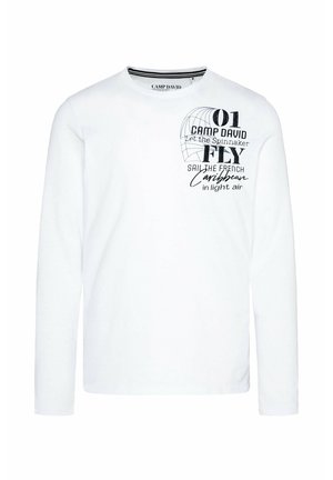 Camiseta blanca de manga larga hecha de algodón, con texto impreso y diseños en negro en la parte delantera, incluyendo un globo terráqueo y motivos de vela.