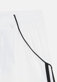 Bijele atletske kratke hlače s elastičnim pojasom, s crnom vezicom i bočnim detaljima. Glatka tekstura tkanine s minimalnim detaljima.