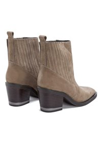 Nupukista valmistetut nilkkasukat, taupen väriset, jossa on ribbitetty varsi ja paksu lohko korko. Varustettu vetonauhoilla helppoa pukemista varten.