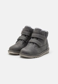 Botas grises hasta media pantorrilla con dos correas ajustables de velcro, forro interior suave gris, exterior de cuero liso y suela de goma texturizada.