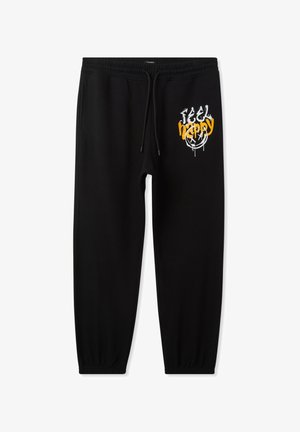 Pantaloni sportivi neri con cintura elastica, cordino regolabile e grafica "FEEL HAPPY" in bianco e giallo sulla coscia sinistra.