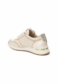 Zapatilla deportiva beige con superficie de cuero suave, acentos metálicos dorados, talón texturizado y suela de goma. Cuenta con sistema de cordones y cuello acolchado.