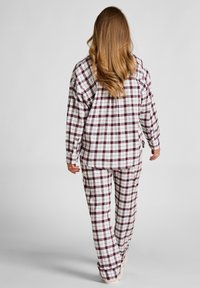 Geruite pyjama set in wit en bordeauxrood; lange mouwen shirt en broek gemaakt van zachte stof. Ruime pasvorm met normale manchetten en zoom.