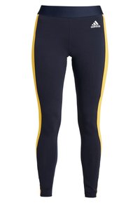 Granatowe legginsy o gładkiej teksturze i dopasowanym kroju, z żółtymi paskami po bokach i logo Adidas na pasku.