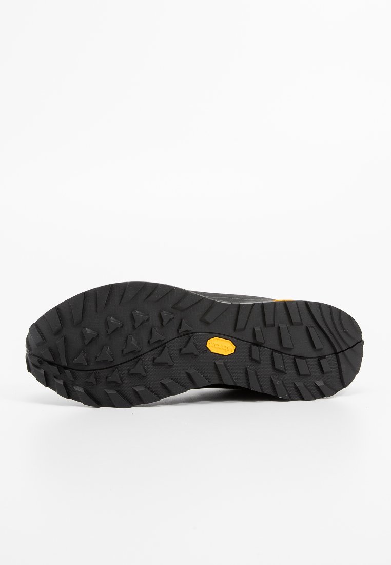 Schwarze Wanderschuhsohle mit einem robusten Profilmuster, das ein gelbes Vibram-Logo und tiefe Rillen für besseren Grip aufweist.