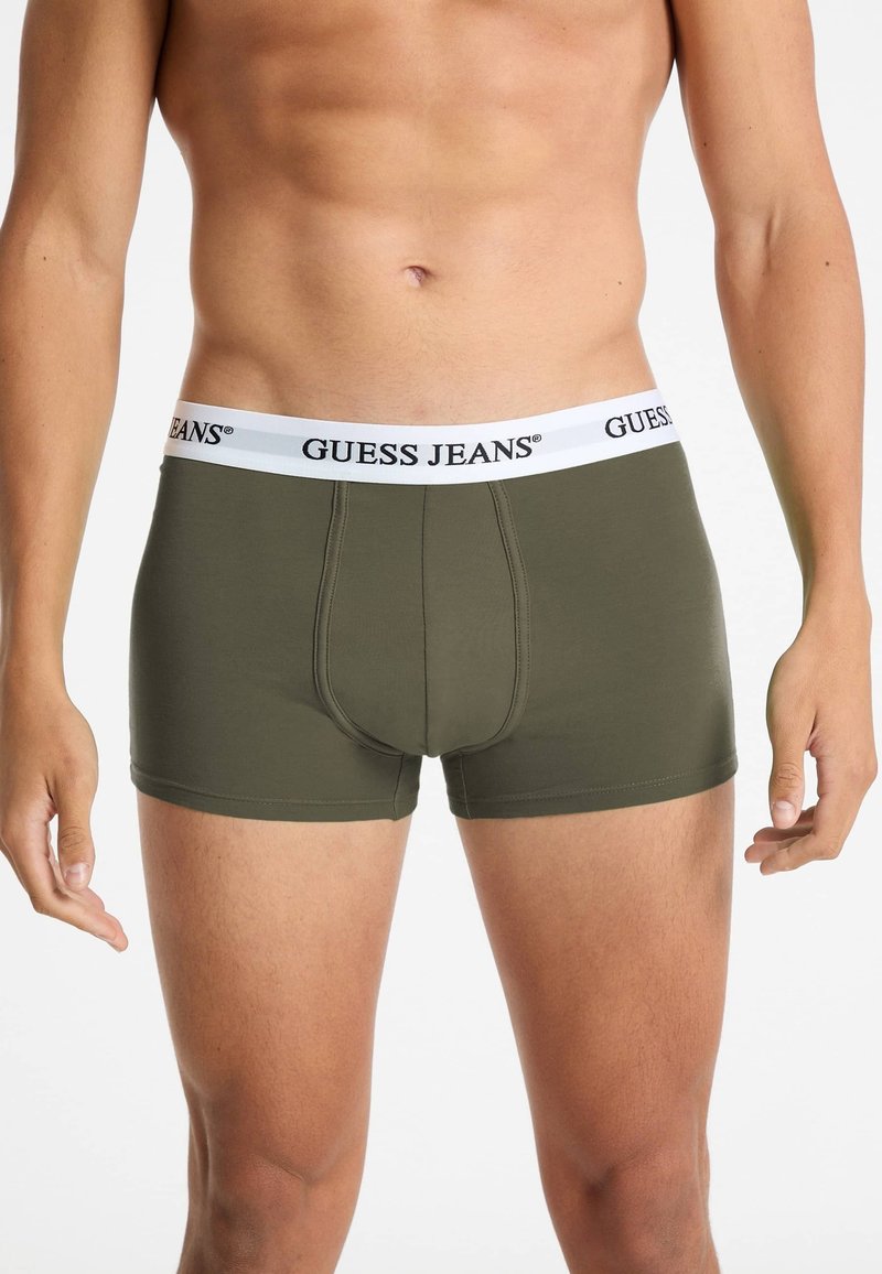 Boxer aderenti verde oliva con una cintura bianca "GUESS JEANS". Realizzati in un tessuto liscio e elastico con un design della sacca sagomata.
