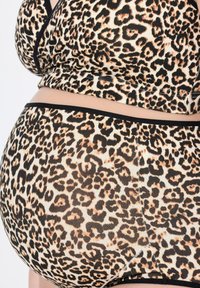 Setti loungewear kuosia leopardilla mustilla yksityiskohdilla. Sisältää istuvan yläosan ja siihen sopivat alushousut pehmeästä, joustavasta kankaasta.