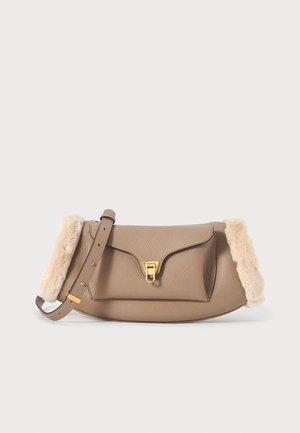 Leather handbag in beige with a fluffy cream trim, gold-tone hardware, a flap closure, and an adjustable strap. Smooth texture.