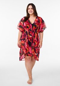 Kimono transparente floral en rojo, rosa y negro, con mangas cortas y cinturón atado. La tela ligera presenta un patrón de hojas.
