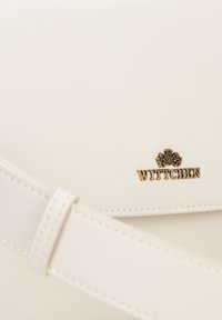 Borsa a tracolla in pelle bianca con una texture liscia. Presenta un logo "Wittchen" in tono oro e una tracolla cucita per una chiusura sicura.