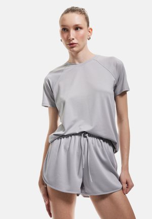 Grijs sportset bestaande uit een T-shirt met korte mouwen en raglanmouwen, en shorts met trekkoord, gemaakt van soepel en lichtgewicht materiaal.