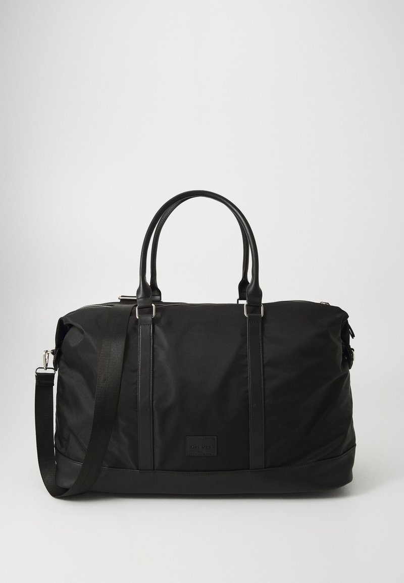 Black duffel bag made of nylon with synthetic leather accents, featuring dual handles and a removable shoulder strap. Textured surface.