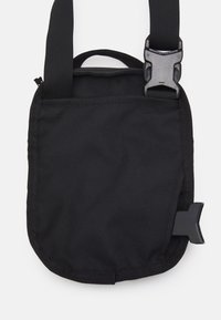 Czarna torebka crossbody z tkaniny o teksturowej powierzchni, regulowanym pasku, górnym uchwycie i akcentem w postaci czarnej plastikowej klamry. Kompaktowy i prosty design.