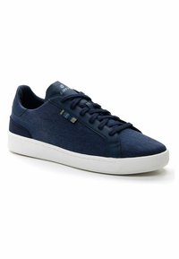 Mornarsko modri športni čevlji z teksturiranim tkaninskim zgornjim delom in gladkimi usnjenimi dodatki. Imajo bel gumijast podplat ter vezalno obliko z detajlom logotipa.