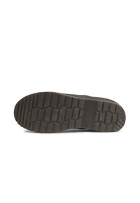 Black rubber shoe sole with a textured, zigzag grip pattern. Flat design with a rounded toe and a slightly raised heel.