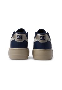 Dunkelblaue Sneaker aus glattem Leder mit beiger Sohle und strukturierten Rückenkontrasten, die ein Logo und einen gepolsterten Kragen aufweisen.