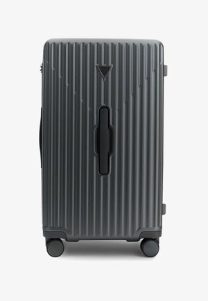 Harde koffer in donkergrijs, voorzien van verticale ribbels, een centrale handgreep en vier wielen voor mobiliteit.