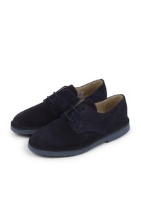 Scarpe in suede blu navy con design stringato, punta arrotondata e suola in gomma blu a contrasto. Presentano dettagli cuciti e una superficie testurizzata.