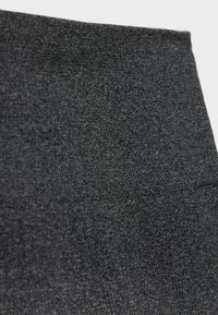 Primer plano de una tela de punto de color gris oscuro con una superficie suave y texturizada y un sutil patrón jaspeado.