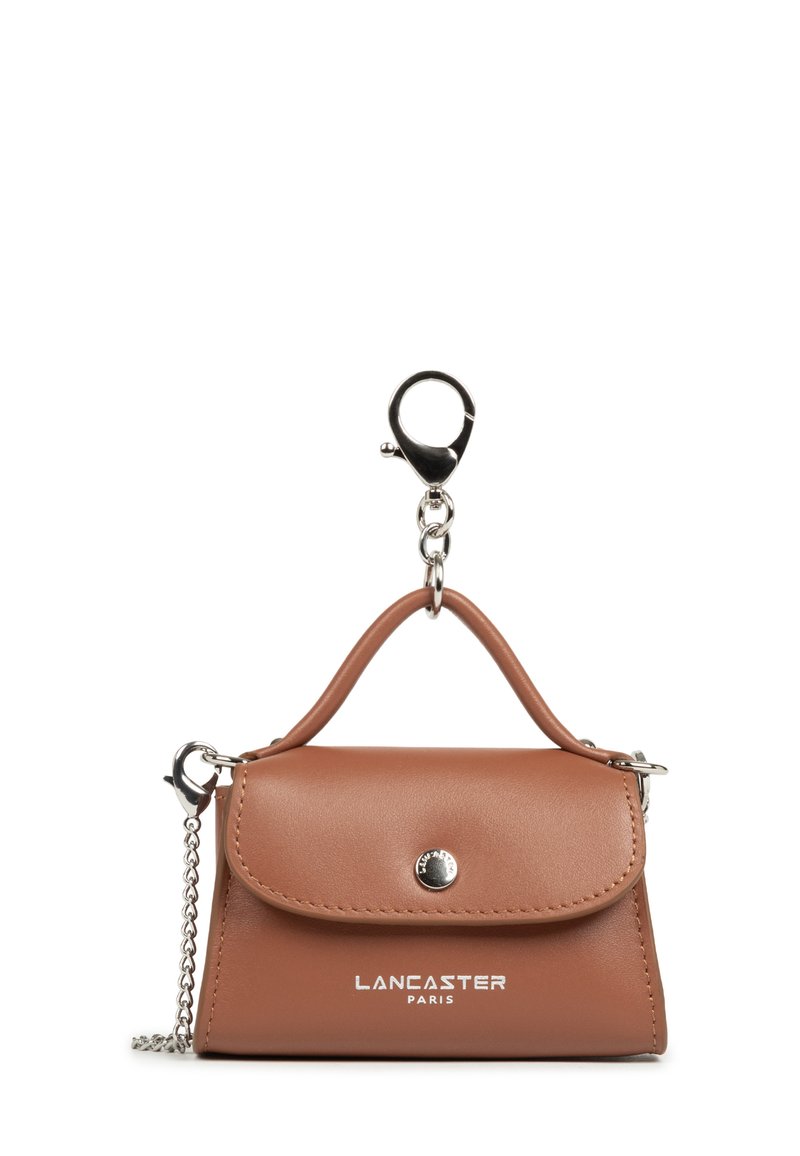 Small brown leather handbag keychain with silver button, chain, and "Lancaster Paris" logo on front.