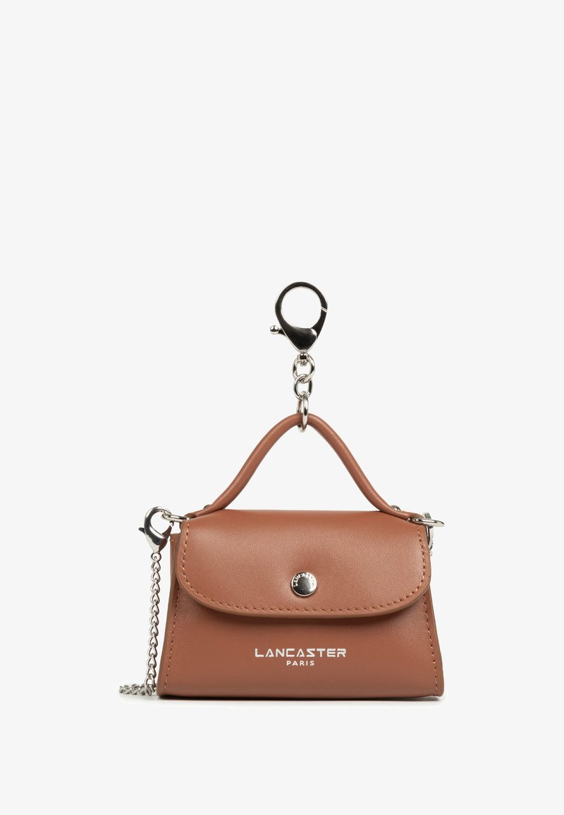 Kleine bruine leren handtas sleutelhanger met zilveren knop, ketting en "Lancaster Paris" logo op de voorkant.