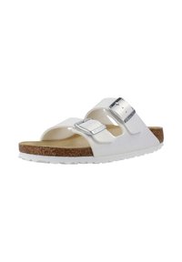 Witte slide-sandalen met dubbele verstelbare metalen gespen, een gestructureerde synthetische bovenkant en een kurken voetbed op een witte rubberen zool.