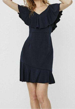 Granatowa sukienka z warstwowymi falbanowymi rękawami, dopasowanym górnym partiem i rozkloszowanym, nierównym dołem. Wykonana z gładkiego materiału o subtelnym połysku.